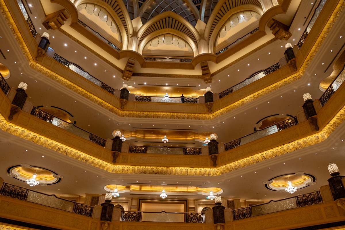 The interior atrium of a luxury hotel, lit warmly from tiered balconies
